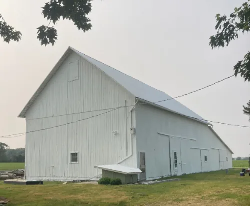 The same barn after: fresh, even white paint on every wall